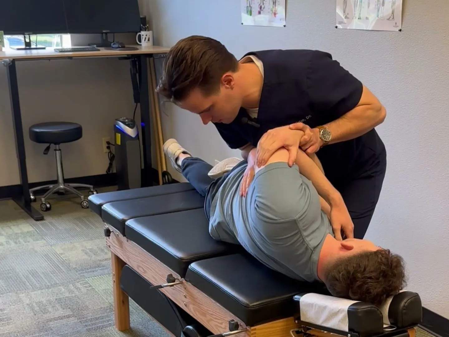 Dr. Douglas Ortyn guiding a patient’s shoulder and upper back during hands-on treatment